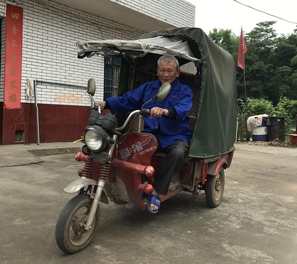(许光华骑三轮车拉材料)