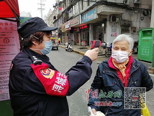 梁学英在对居民进行体温测量.