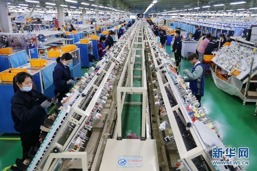 3月9日,在安徽淮北高新技术产业开发区,工人在汽车线束生产线上忙碌.