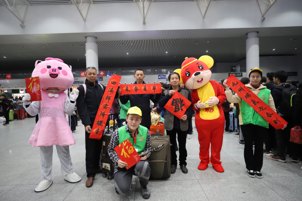 图五：1月10日，在南昌站候车厅，南昌工务段青年志愿者们向旅客赠送春联。