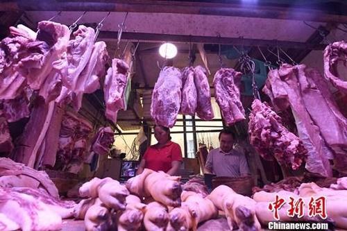 资料图：农贸市场内，商贩正在摆放猪肉。<a target='_blank' href='http://www.chinanews.com/'><p  align=