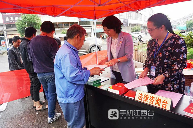 挂职教师在为基层群众发放普法资料解答法律问题