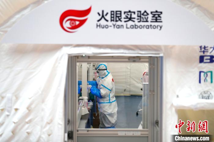 透过舱门窗户看到身穿防护服的工作人员正在紧张地忙碌。　富田 摄