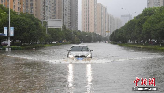 资料图：一条道路出现积水，车辆行驶其中激起水波。<a target='_blank' href='http://www.chinanews.com/'>中新社</a>记者 王刚 摄