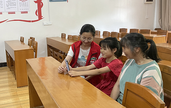 杨岐村学雷锋志愿服务队帮助留守儿童与在外务工亲人连线