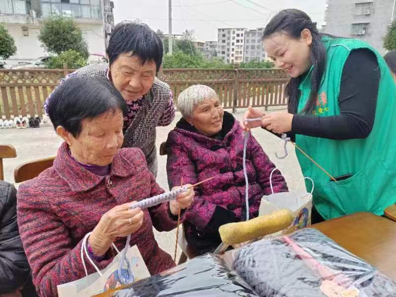 志愿者和老人交流织围巾的方法