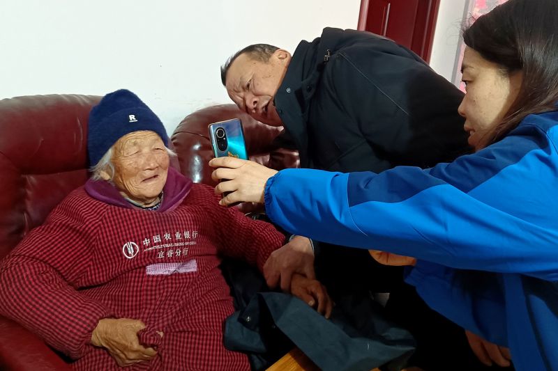 窑前社区网格员上门为行动不便的眼疾老人以“免眨眼”方式办理农保年检手续。蔡奇 摄