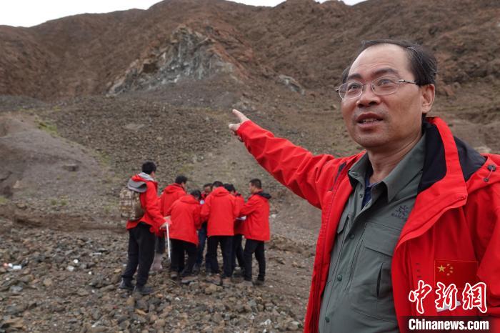 中科院青藏高原所方小敏研究员在青藏高原科考途中，介绍一处高原地质地貌。　中新社记者 孙自法 摄