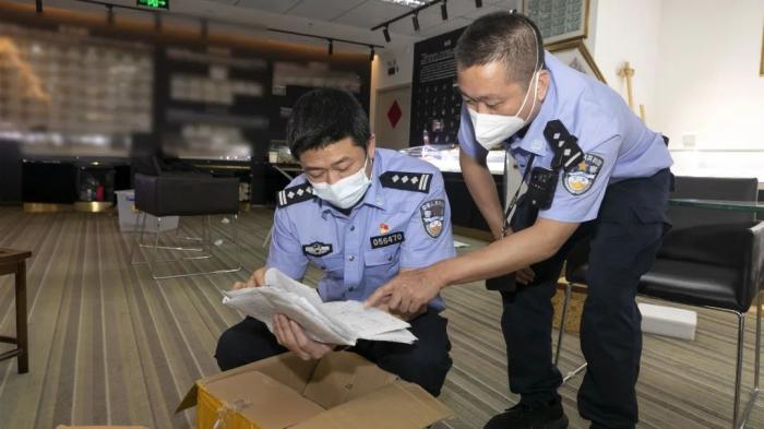 ▲办案民警在清点作案票据