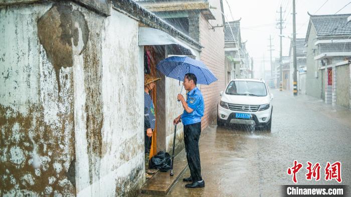 孙益海冒雨走访村民。　公安部供图