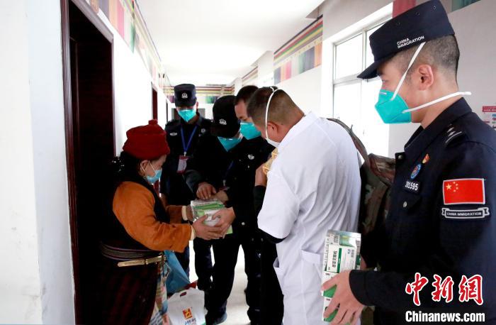 移民管理警察为驻地敬老院尼玛顿珠老人解说肠胃药的服用说明。　肖富贵 摄