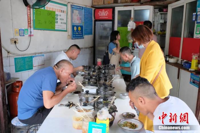 食客们正在狭窄的粥摊内用餐。刘俊聪 摄 食客们正在狭窄的粥摊内用餐。刘俊聪 摄