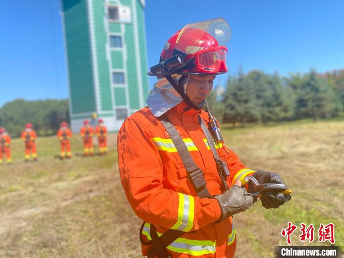 图为陆坤讲解滑降绳卡扣的操作步骤。　张玮 摄