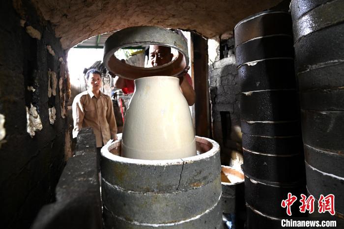 经过长时间烧制后,林俊打开窑门查看烧制成果。 张金川 摄 经过长时间烧制后,林俊打开窑门查看烧制成果。 张金川 摄