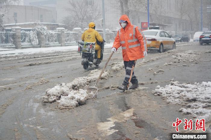 长春环卫工人清理道路积雪。　郭佳 摄