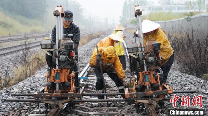 玉林工务段职工冒雨在线路上进行机械捣固作业，整修设备病害。　李慕传 摄