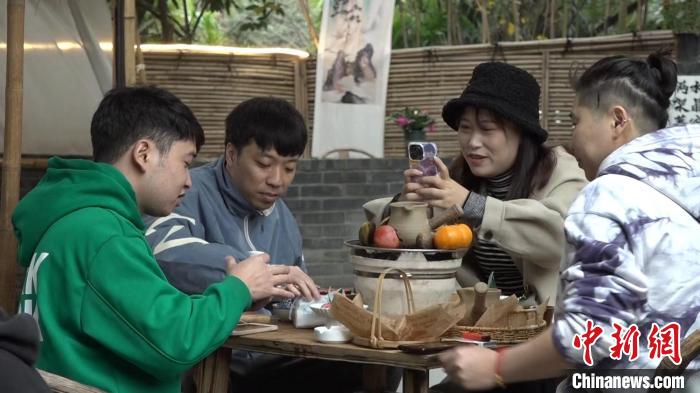 成都一茶馆内,正在“围炉煮茶”的年轻人。 陈选斌 摄 成都一茶馆内,正在“围炉煮茶”的年轻人。 陈选斌 摄