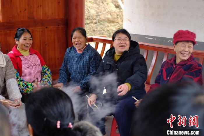 图为杨宁(中)召集村民共同商讨山泉水厂建设问题，大家脸上洋溢着幸福笑容。　刘俊聪 摄