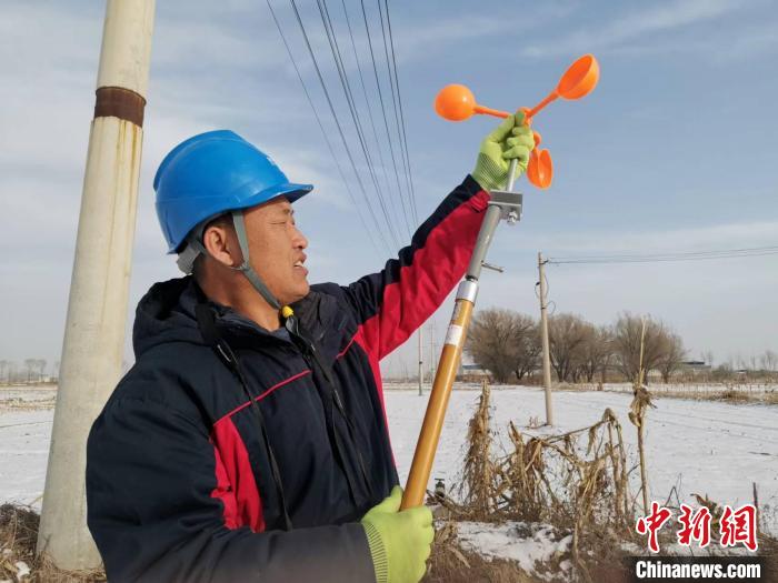 工友演示孟建国创新改进的不停电安装驱鸟器工具。　陆祁国 摄