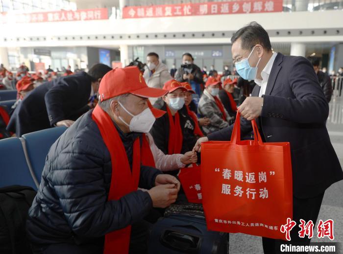 图为重庆人社局相关负责人发放返岗“大礼包”。　重庆人社供图