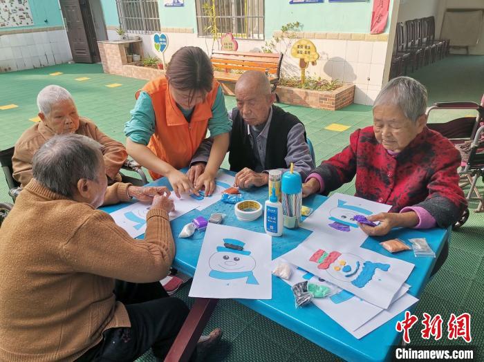 图为甘国霜与老人们一同做手工。 受访者供图 图为甘国霜与老人们一同做手工。 受访者供图