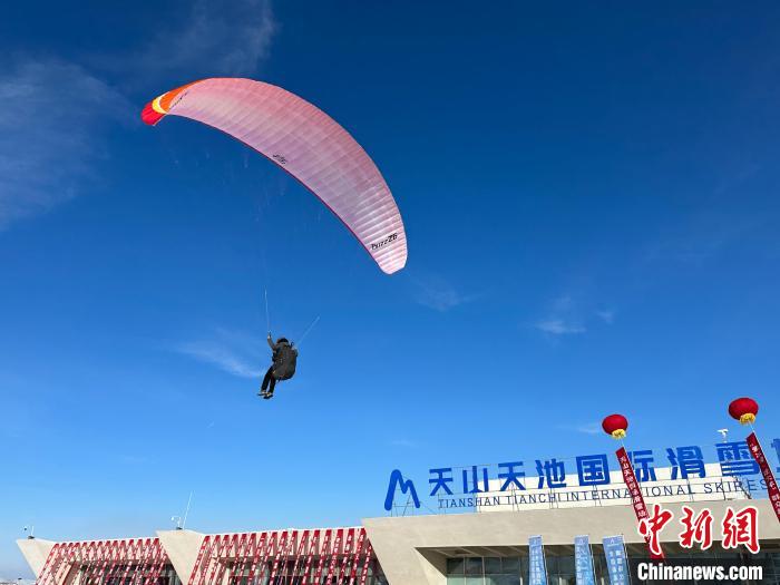 雪地滑翔伞划过天山天池国际滑雪场上空。　张家伟 摄