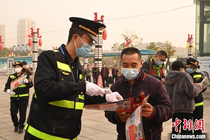 图为执法人员在重庆北站对旅客发放安全乘车宣传资料，并提供引导。　张旭 摄