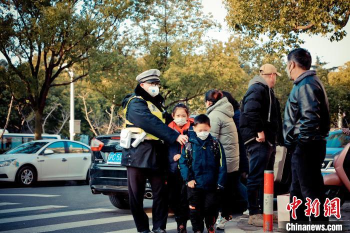 青浦区实验小学东校区门前的人流车流接连不断，但是在民警的的有序指挥下并不显得拥堵。　上海市公安局青浦分局供图