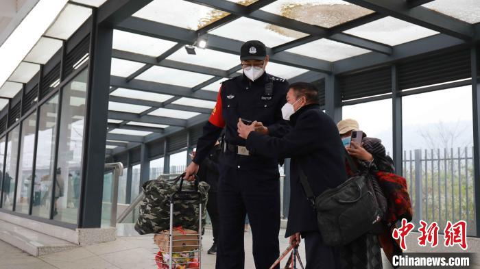 张淇翔给年老旅客指路并帮提行李。　冉景嘉 摄