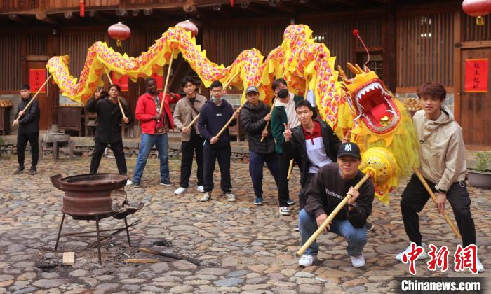 留学生们在土楼里体验舞龙表演。　华侨大学文学院 供图