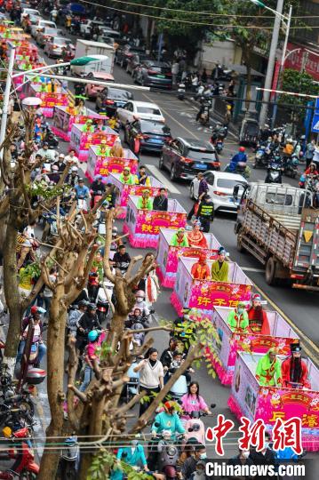 2月5日，海口市琼山区府城举行“装马匹”民俗祈福巡游。“装马匹”民俗巡游队伍穿过城市街道。　骆云飞 摄