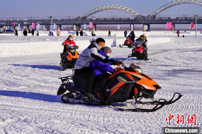 游客在哈尔滨松花江冰雪嘉年华开雪地摩托 孙汉仑 摄