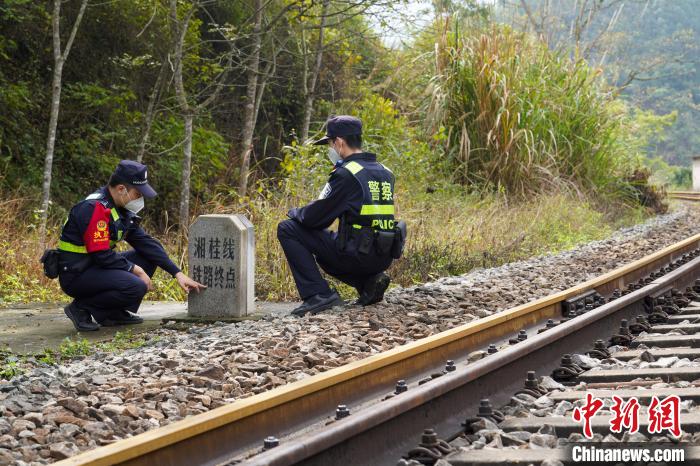 黄炫森在“中越边境湘桂线0公里”向新同事介绍巡线要点。　王以照 摄