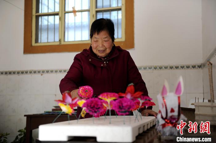 图为王蒲芳将做好的纸花固定在模具上。　高铖 摄