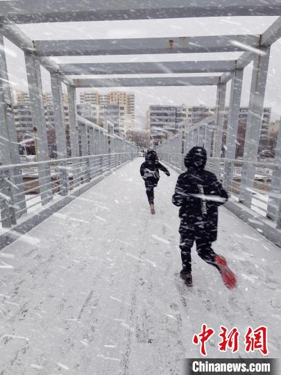 图为2月12日拍摄的孩童在雪地玩耍。　王生荣 摄