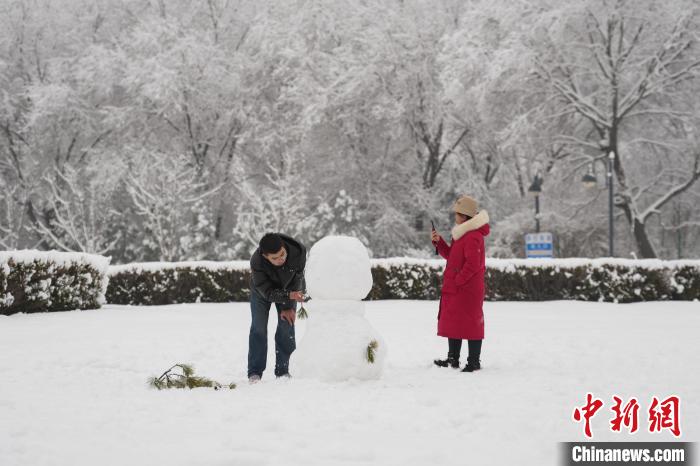 民众正在堆雪人。　武俊杰 摄