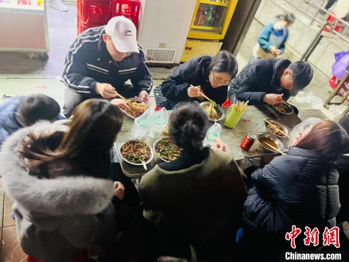 图为众多食客正围坐品尝螺蛳粉。　刘俊聪 摄