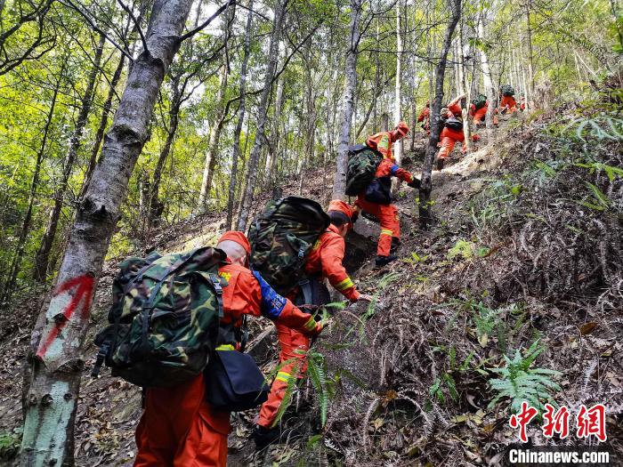 消防员准备有序通过陡坡。　靳建坤 摄