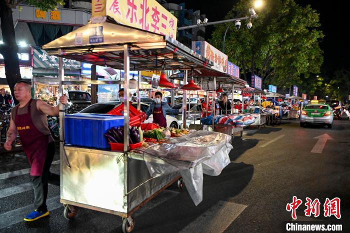 珠海夏湾夜间特色小吃街开市在即，商贩们拉着小推车快步有序入场 陈骥旻 摄