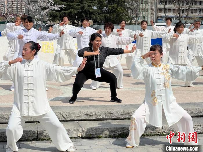 外籍友人与晨练的居民互动。　刘夏 摄