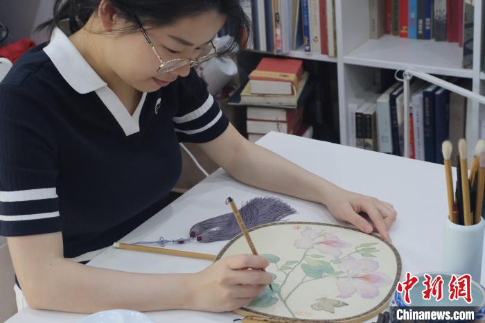 图为何媛正在团扇上绘画。 刘俊聪 摄 图为何媛正在团扇上绘画。 刘俊聪 摄