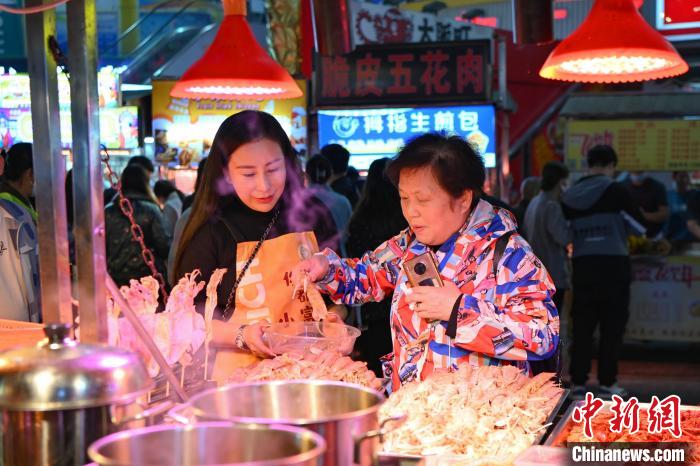 姜美合(左)珠海夏湾夜间特色小吃街的经营着其中一个档口 陈骥旻 摄