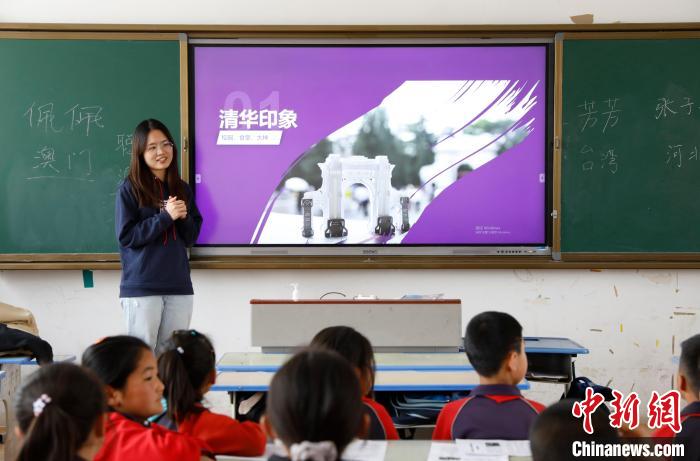 来自澳门的清华学子向小朋友介绍清华大学。　杨迪 摄