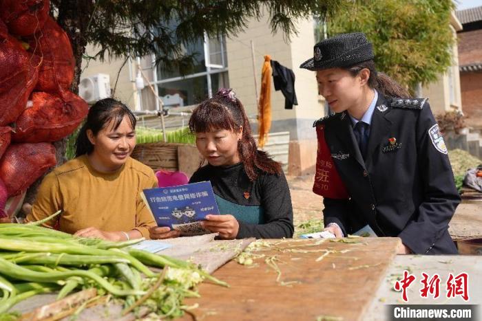 图为女子调解队成员与民警进入村民家中进行普法宣传。　王婷 摄