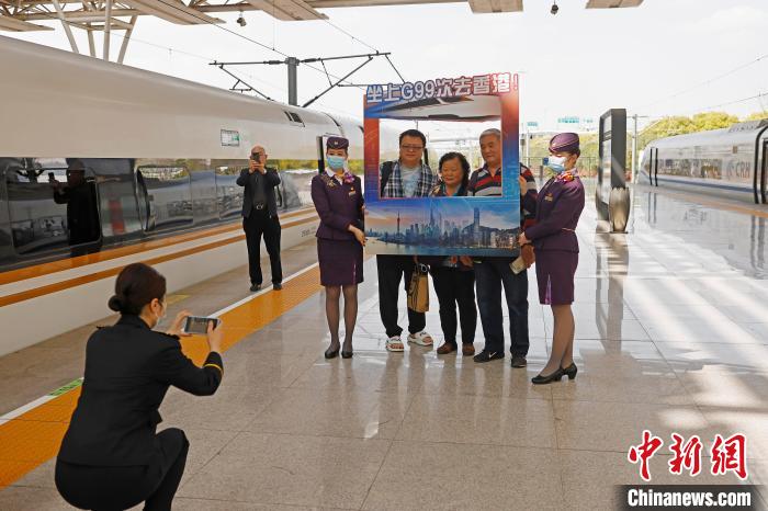 旅客和列车员在上海虹桥至香港西九龙G99次列车外合影。　殷立勤 摄