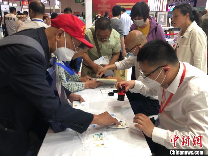 图为集邮爱好者在现场加盖邮戳。 叶娜 摄 图为集邮爱好者在现场加盖邮戳。 叶娜 摄