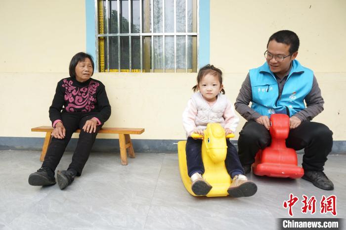 图为4月11日，黄保持(右一)与女儿、母亲在居住的村委楼房前玩耍。　欧惠兰 摄