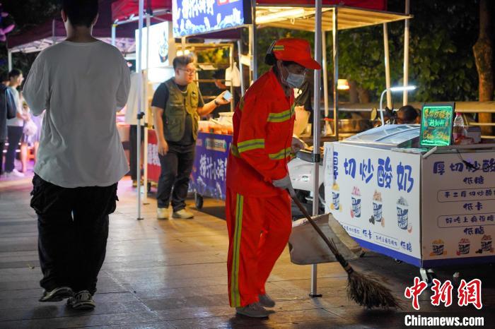 图为环卫工人在柳州风情港夜市打扫卫生。　韦国政 摄