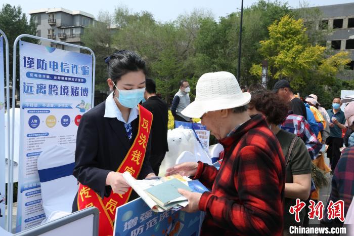 活动现场，反洗钱宣传员普及经济犯罪防范知识。　辽宁省公安厅供图