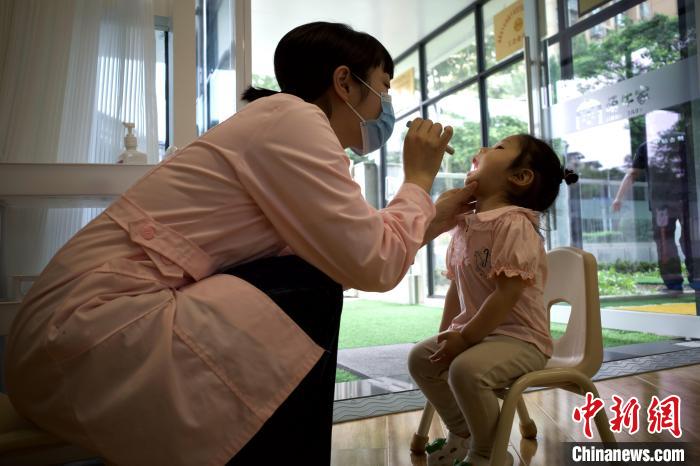 成都一托幼机构中，保健员给幼儿检查口腔。　王鹏 摄